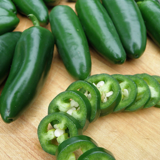 Fresh green jalapeno peppers, whole and sliced, ready for cooking and gardening. HarvestNest Seeds